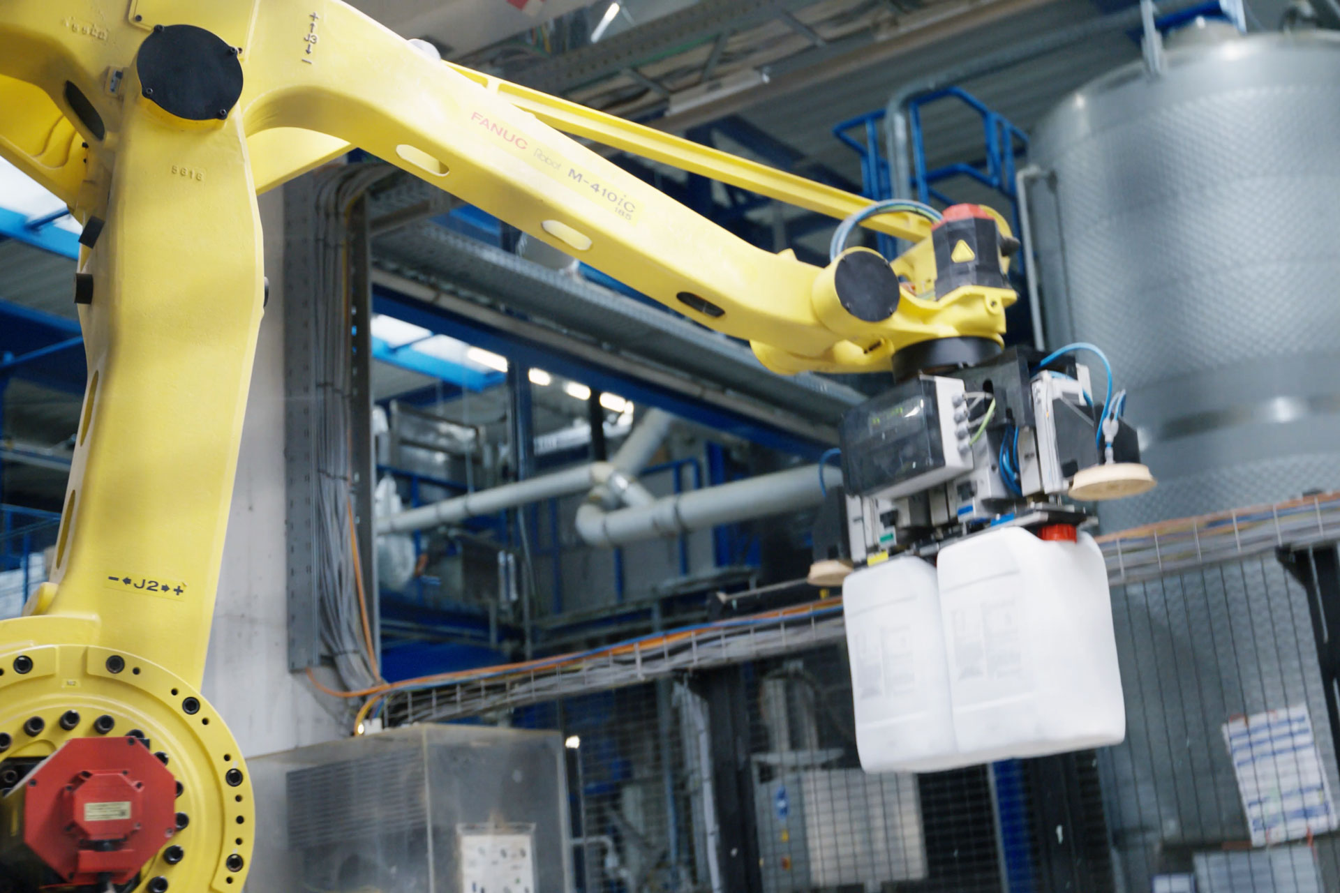 Roboterarm greift Kanister in Viovera Blattdünger Produktion